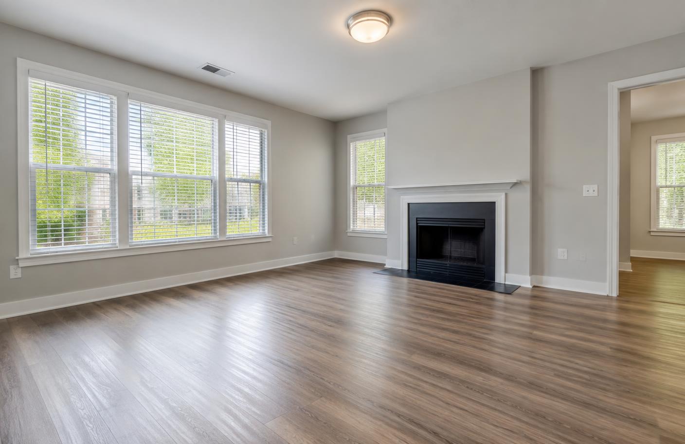A vacant apartment living room with clean floors ready for a walkthrough.